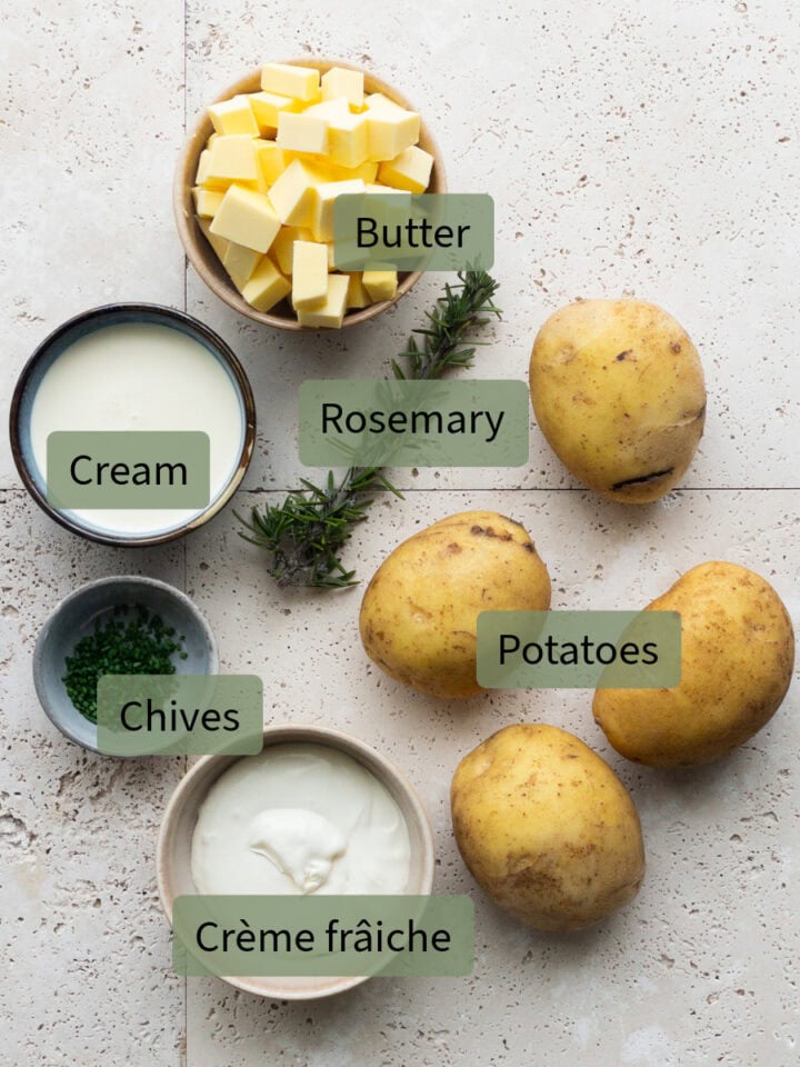 Ingredients on the bench; from top left: diced butter, cream, rosemary sprig, chopped chives, Agria potatoes and crème fraîche.