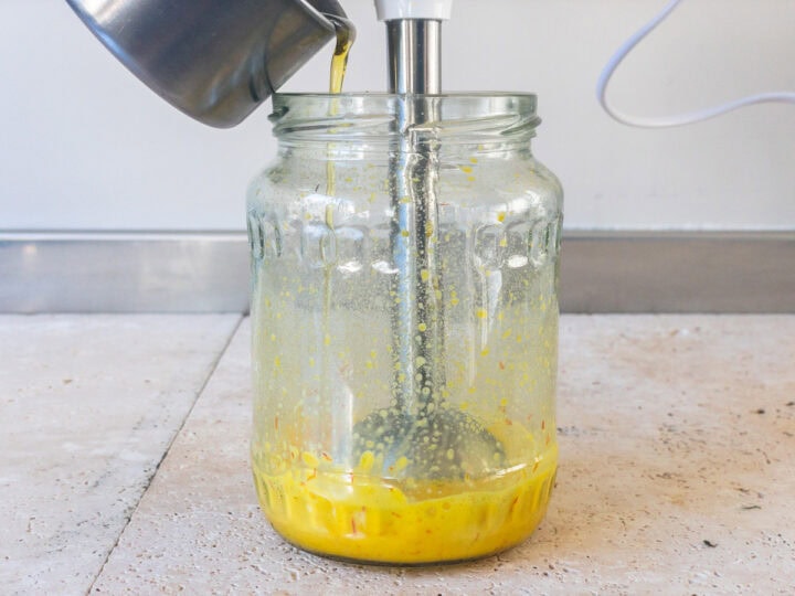 Saffron emulsion is blended in a glass jar with an immersion/stick blender.