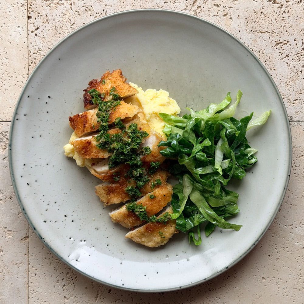 Crispy chicken cotoletta topped with salsa verde and served with creamy mashed potatoes and shredded cos salad.