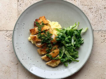 Crispy chicken cotoletta topped with salsa verde and served with creamy mashed potatoes and fresh cos salad.