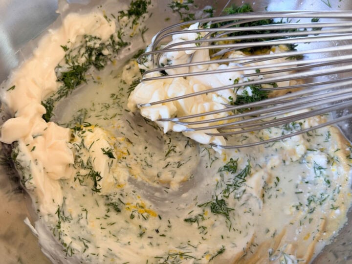 Creamy herb mixture with dill and lemon zest, in a mixing bowl.