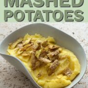 Rosemary mashed potatoes topped with crispy potato skins served in an irregular shaped bowl.