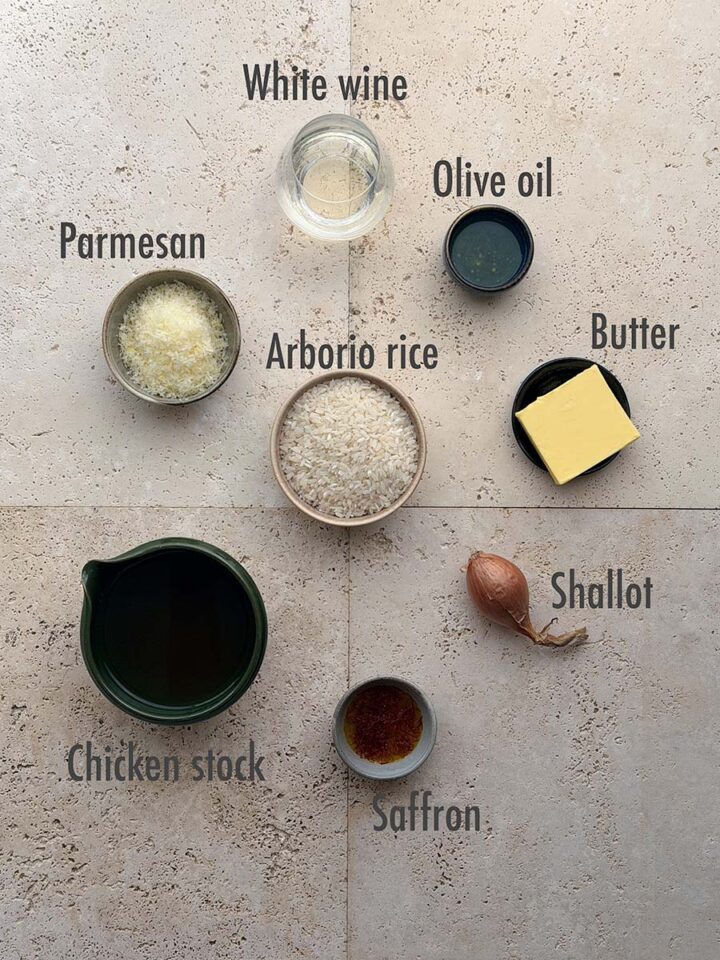 Ingredients for saffron risotto: arborio rice, saffron, shallot, olive oil, white wine, chicken stock, butter and Parmesan