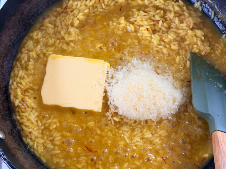 Butter and Parmesan are added to simmering saffron risotto.